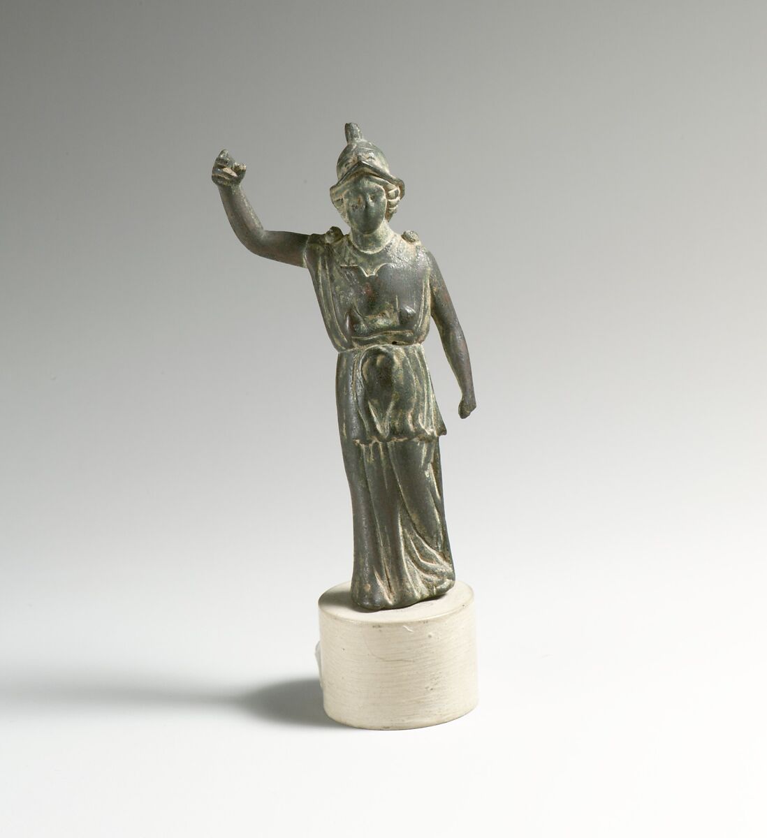 Estatuilla romana de Atenea con casco, brazo derecho levantado y vestido largo con pliegues